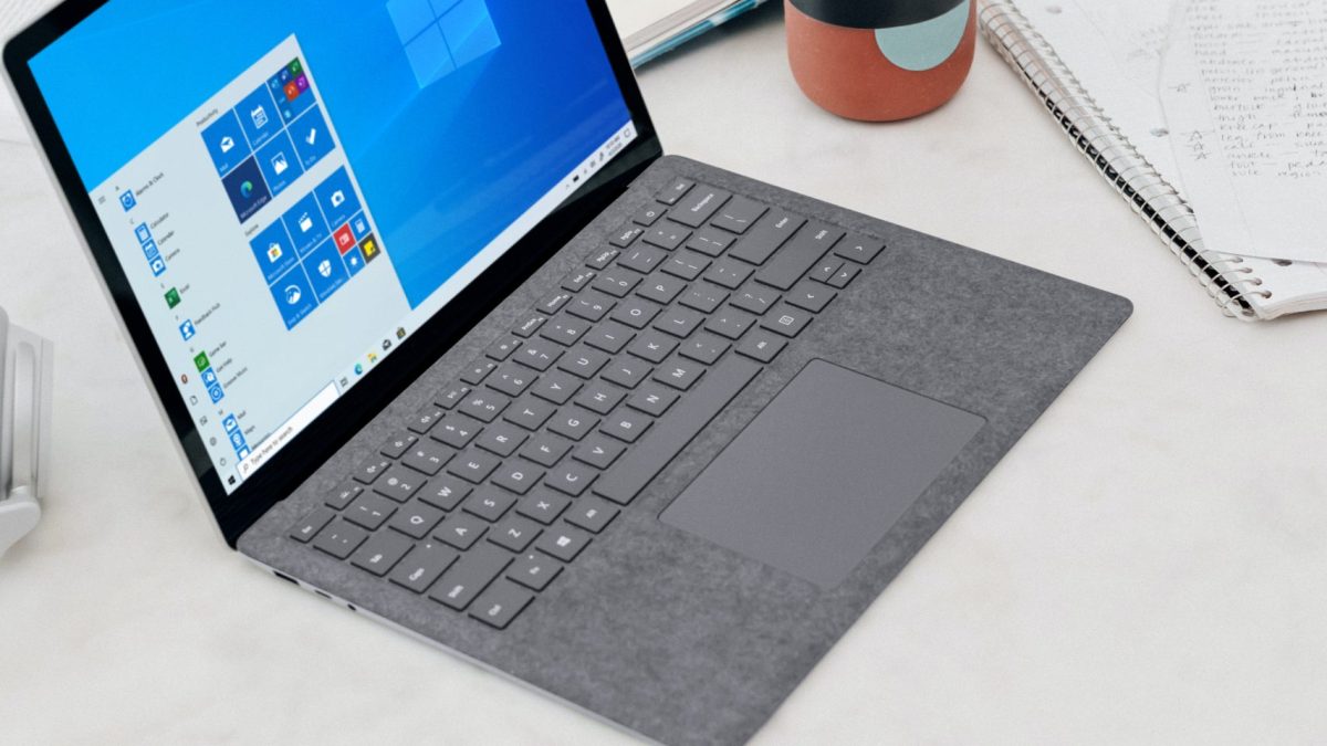 gray microsoft surface laptop computer on white table