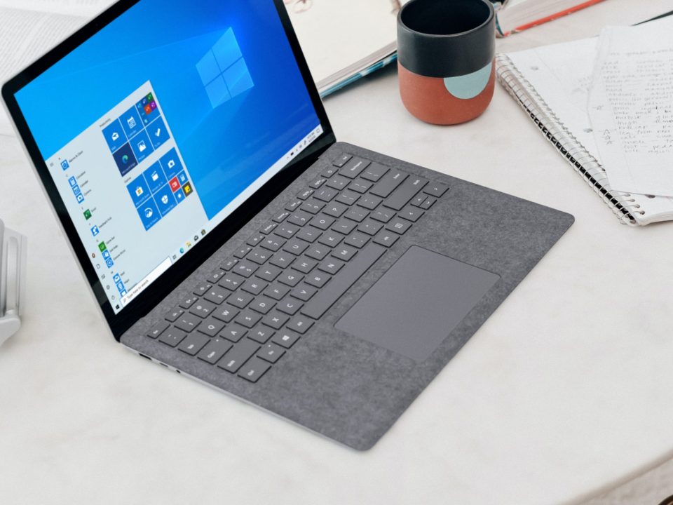 gray microsoft surface laptop computer on white table