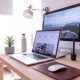 MacBook Pro on table beside white iMac and Magic Mouse