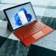 Red Surface laptop on a checkered bed by a window